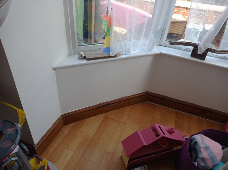 The same bay window wall, with a clean white mould-free finish